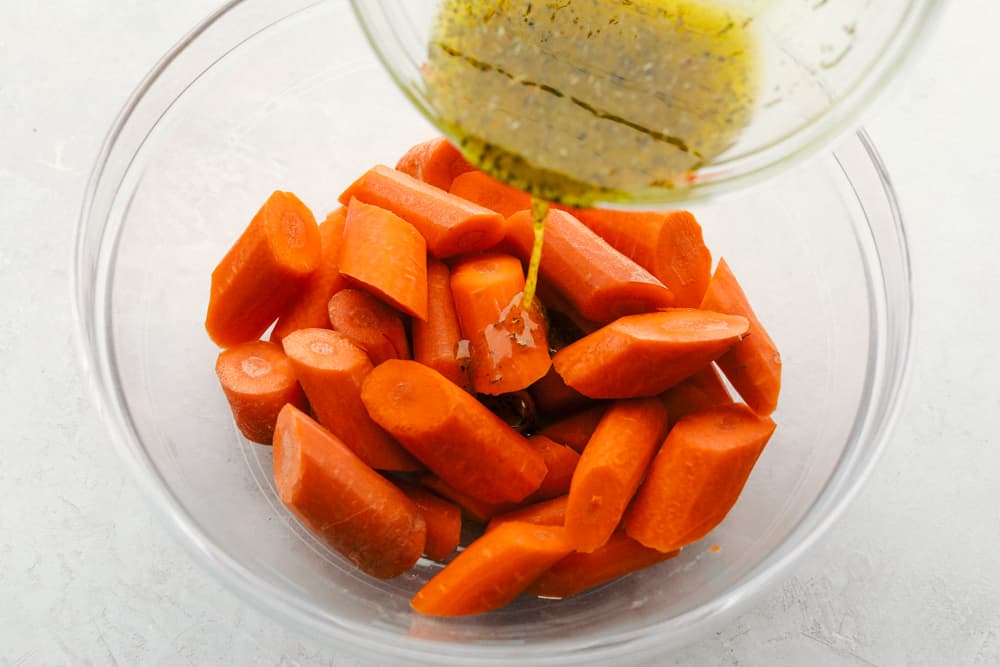 Verter el condimento sobre zanahorias cortadas en rodajas.