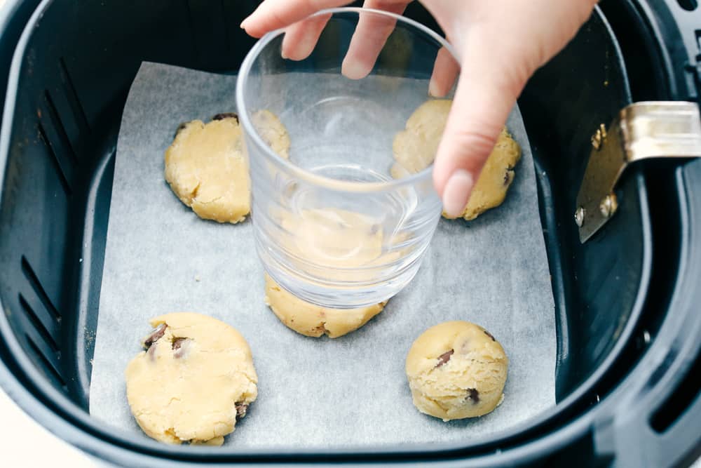 Aplanar las galletas en la freidora con un vaso. 